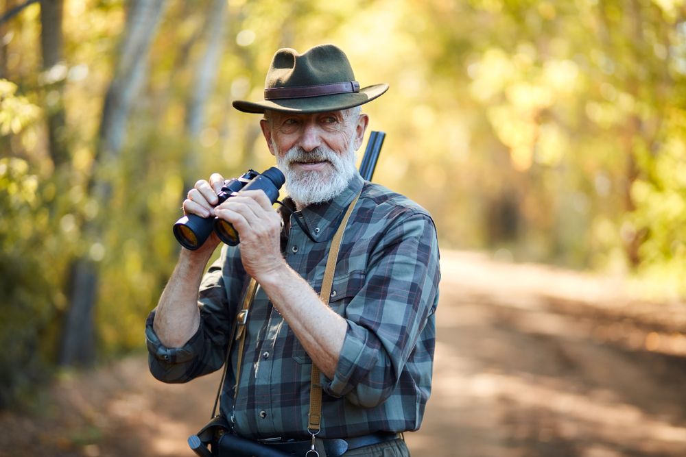 Using,Binoculars,For,Better,Hunting,On,Birds.,Senior,Man,Holding